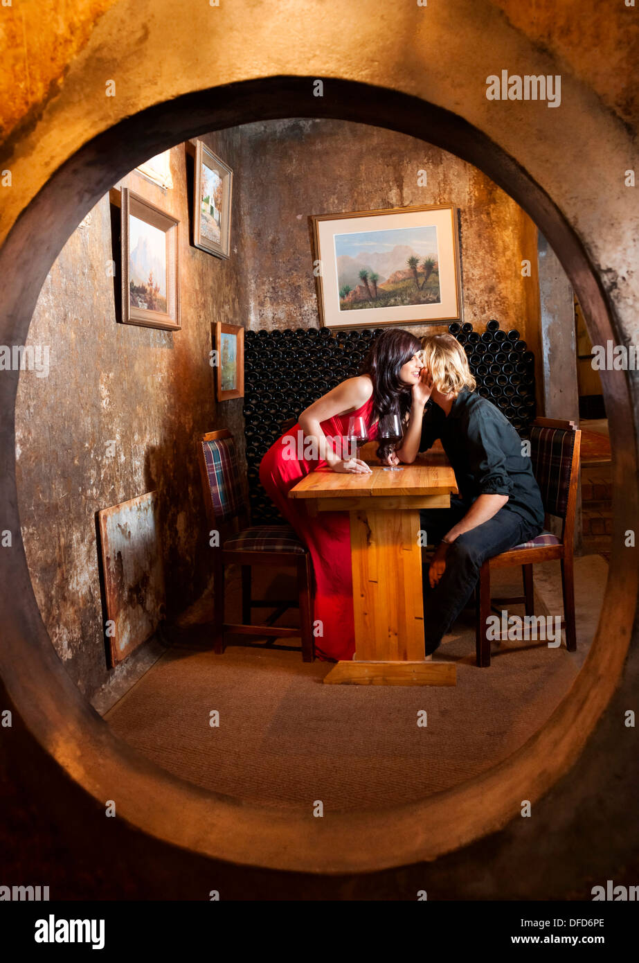 Kaukasische paar in frühen zwanziger Jahren Verkostung Rotwein in einer der gemütlichen Nischen auf Muratie Weingut (1699), Winelands, Stellenb Stockfoto