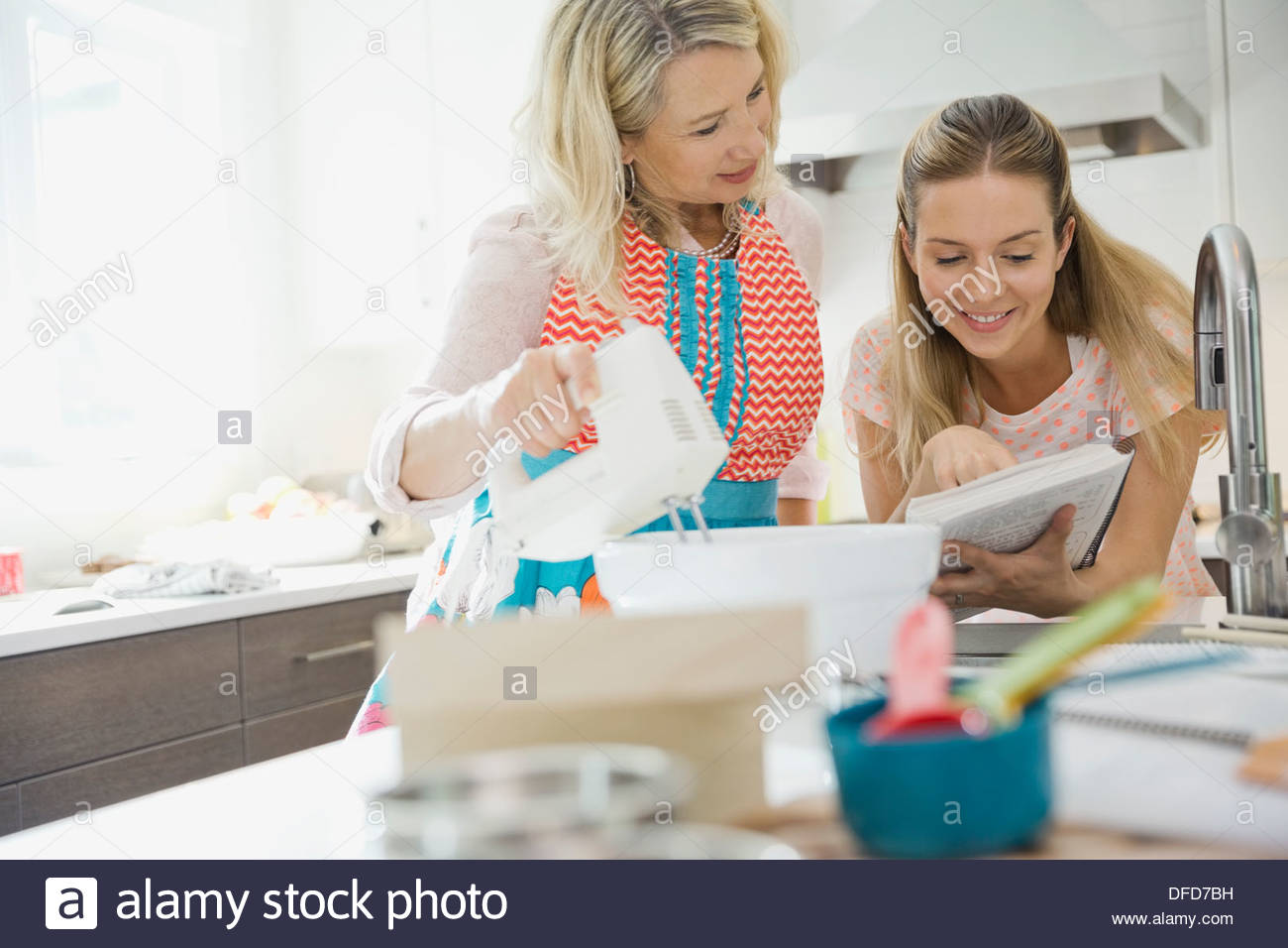 Mutter und Tochter Lesung Rezept während des Backens in Küche Stockfoto