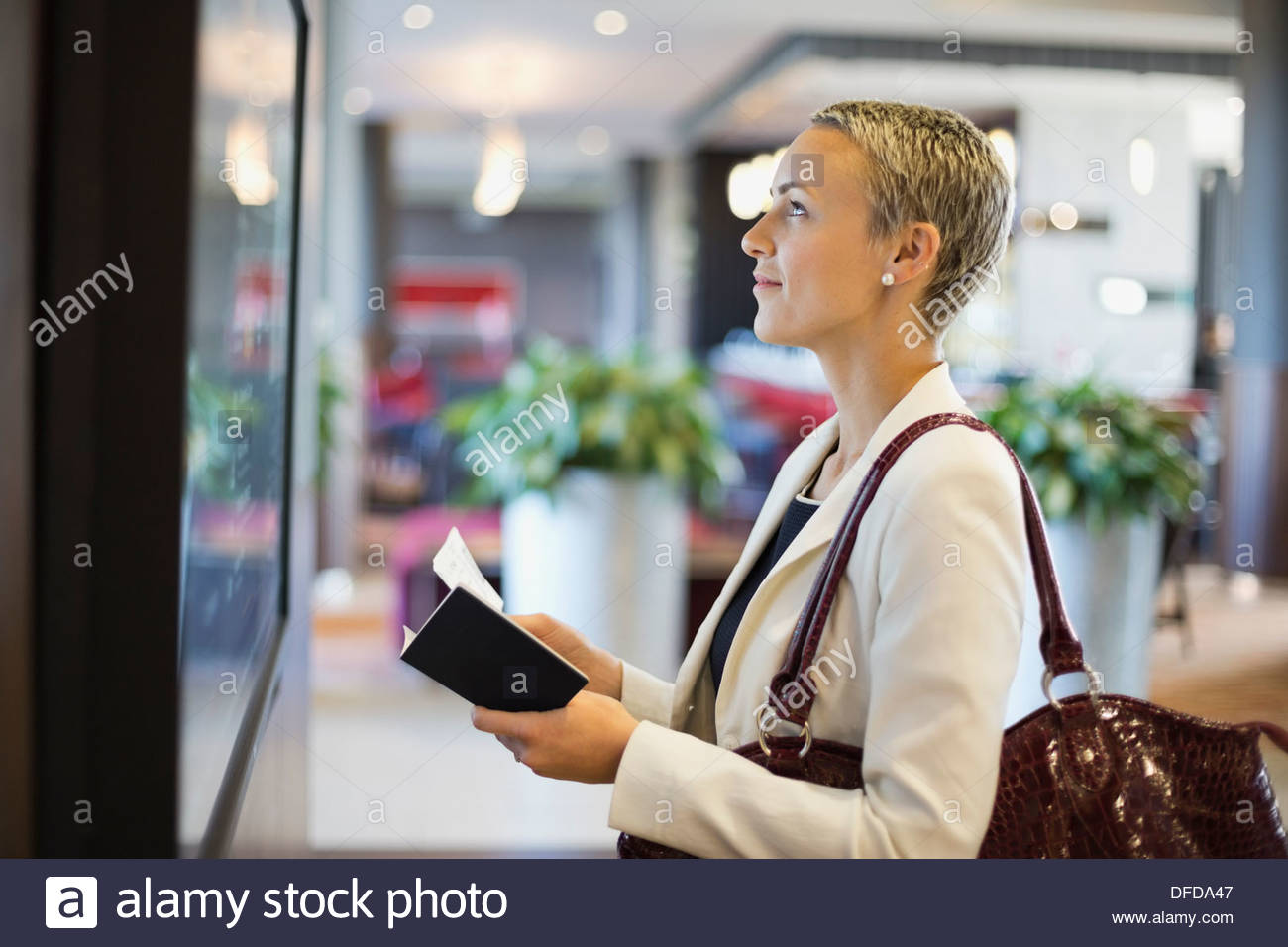 Geschäftsfrau überprüfen Fahrplan am Flughafenterminal Stockfoto