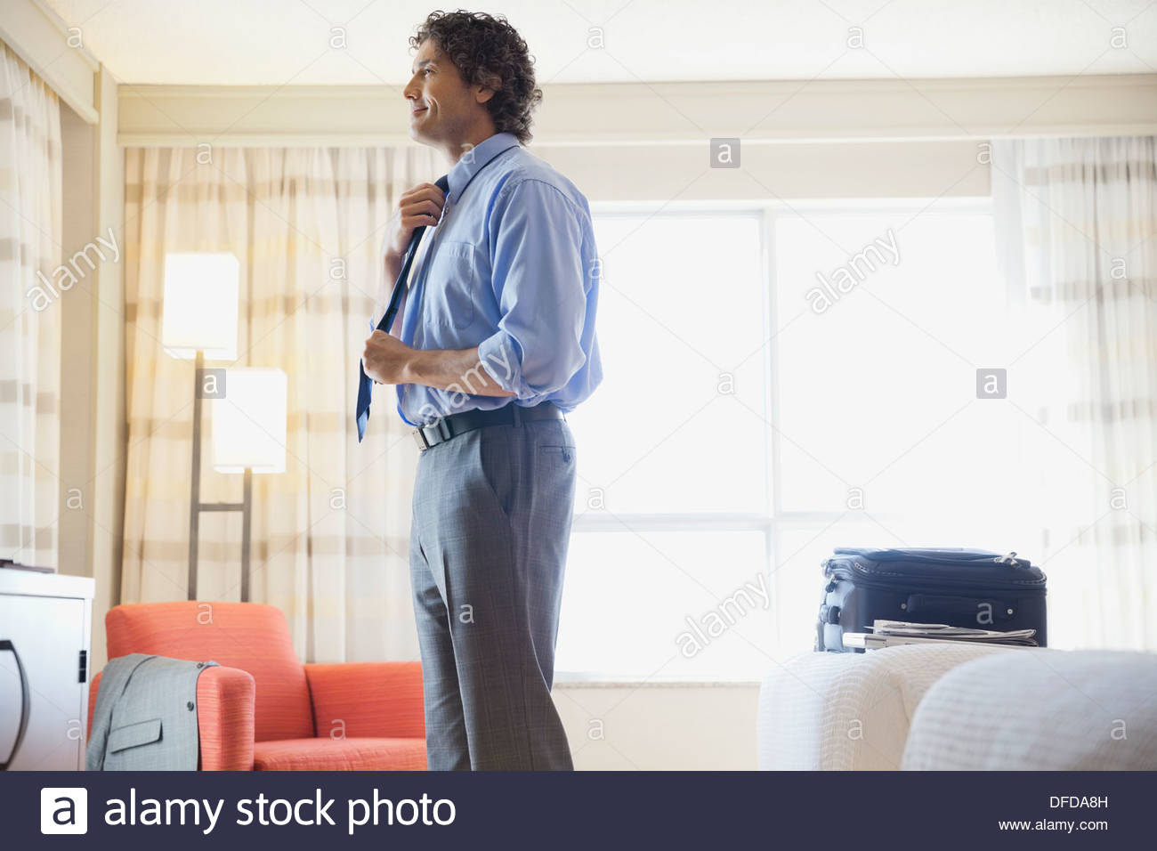 Geschäftsmann Begradigung Krawatte in Hotelzimmer Stockfoto