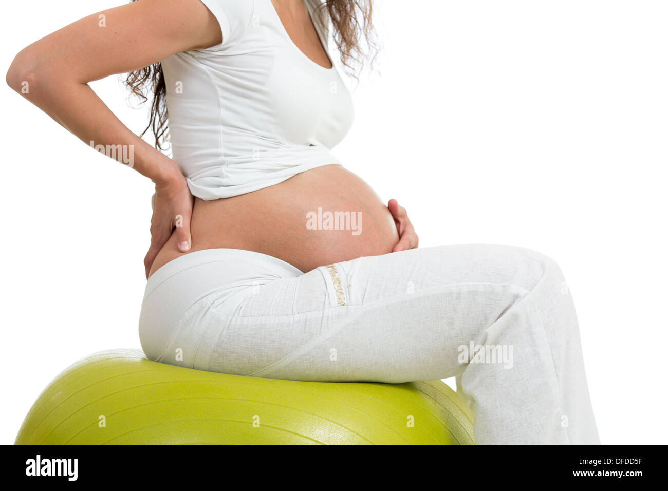 Schwangere Frau sitzen auf Fit Ball mit der Hand auf dem Rücken, isoliert Stockfoto