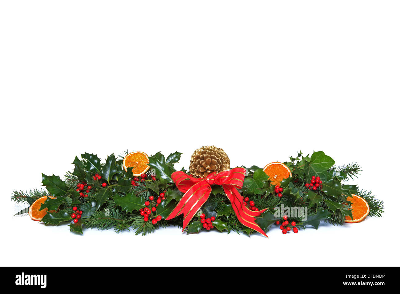 Eine traditionelle Weihnachtsgirlande, hergestellt aus frischen Holly mit roten Beeren, getrocknete orange Segmente, grünen Efeu, frische Nadelbaum Zweige Stockfoto