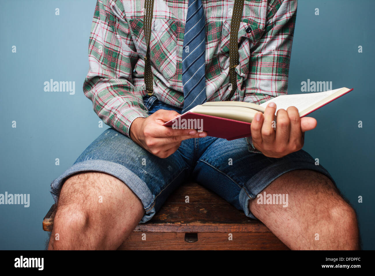 Mann am Schreibtisch sitzen und ein Buch zu lesen Stockfoto