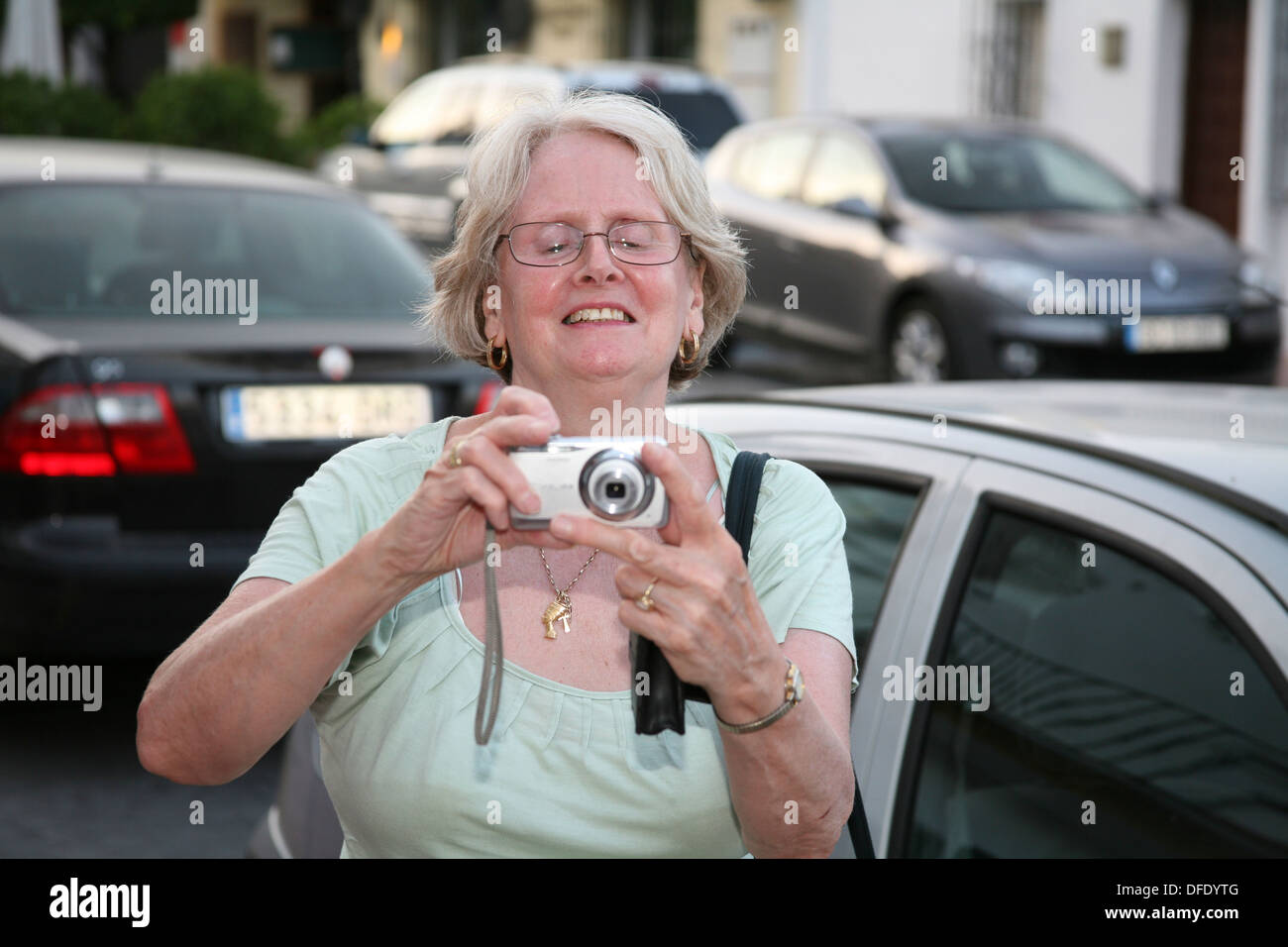 Ältere Frau fotografieren mit Digitalkamera in Straße Stockfoto