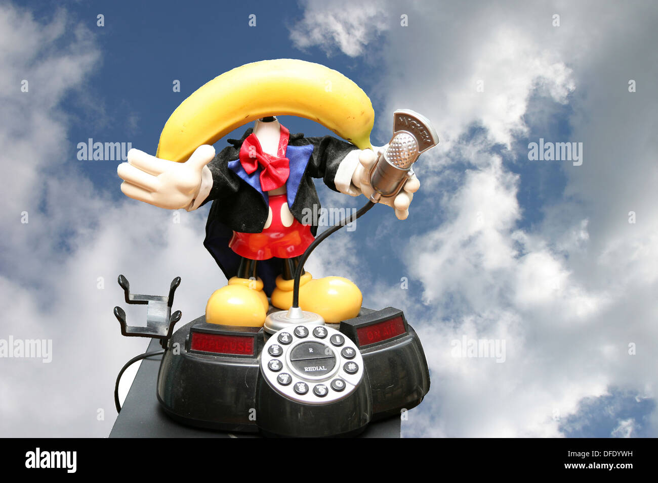 Kitsch anthropomorphe Banane Telefon gegen blauen Himmel mit Wolken Stockfoto