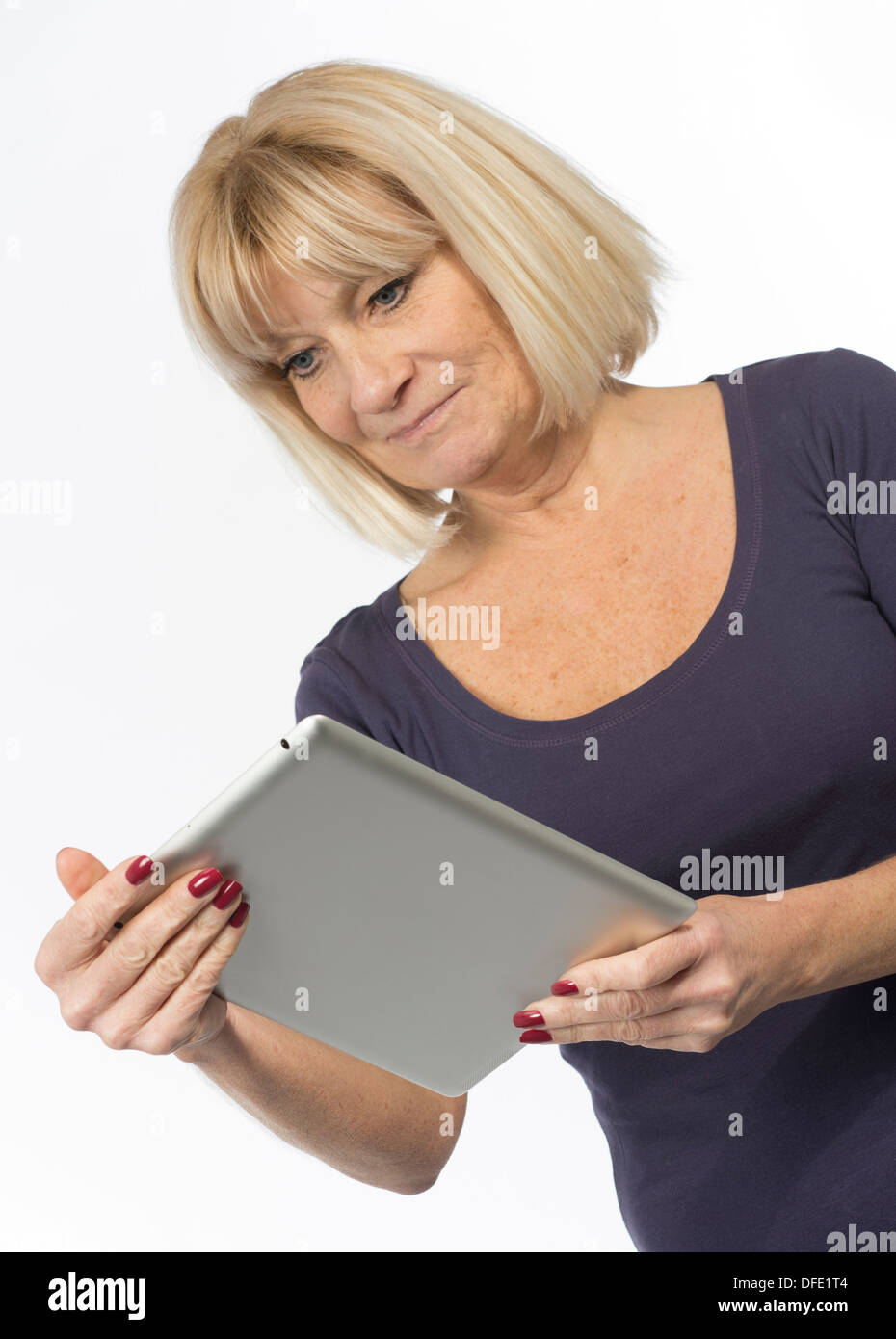 Ältere Frau mit einem Tabletcomputer im Studio auf weißem Hintergrund fotografiert Stockfoto