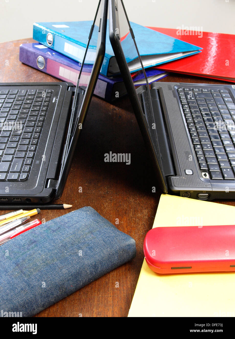 Tisch für Kinder Hausaufgaben mit Rücken an Rücken Laptops, UK Stockfoto