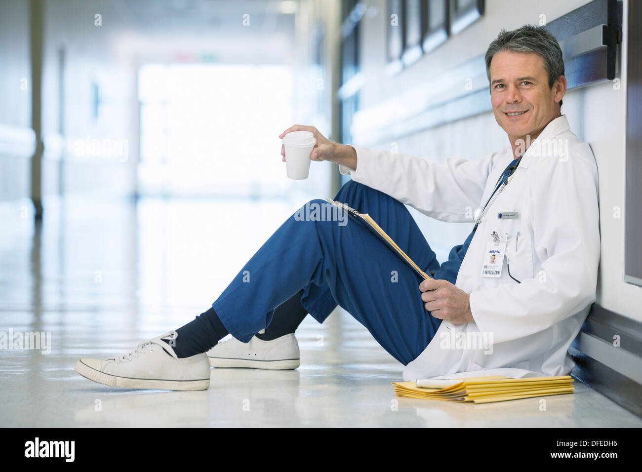 Porträt von lächelnden Arzt Kaffeetrinken im Krankenhausflur Erdgeschoss Stockfoto