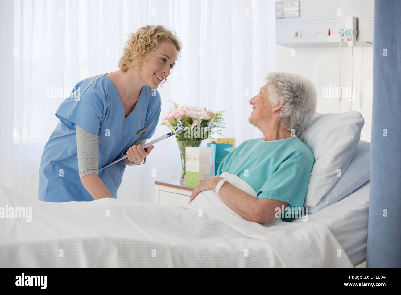 Krankenschwester und Alterung Patient im Krankenzimmer im Gespräch Stockfoto