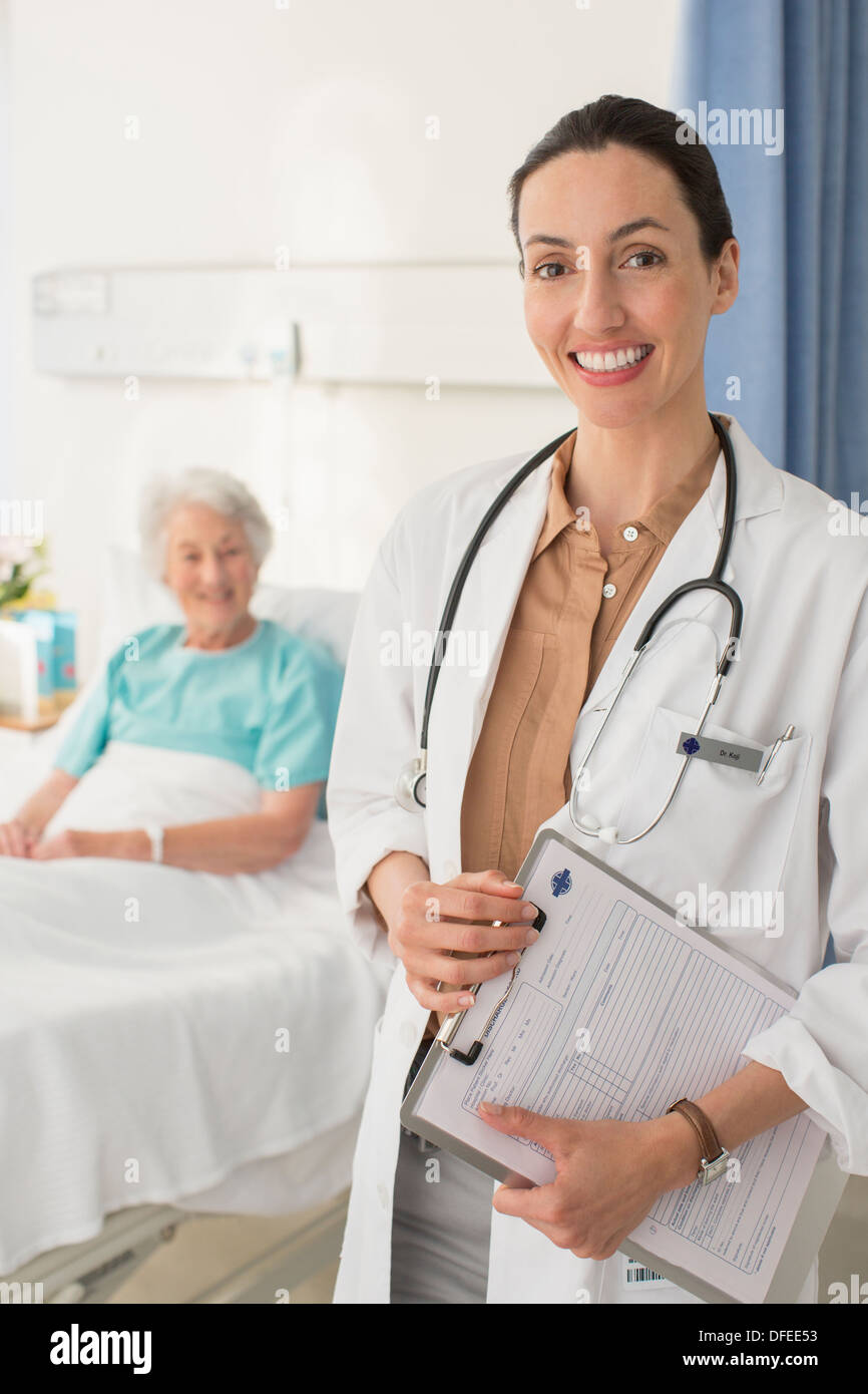 Porträt von lächelnden Arzt mit älteren Patienten im Hintergrund Stockfoto