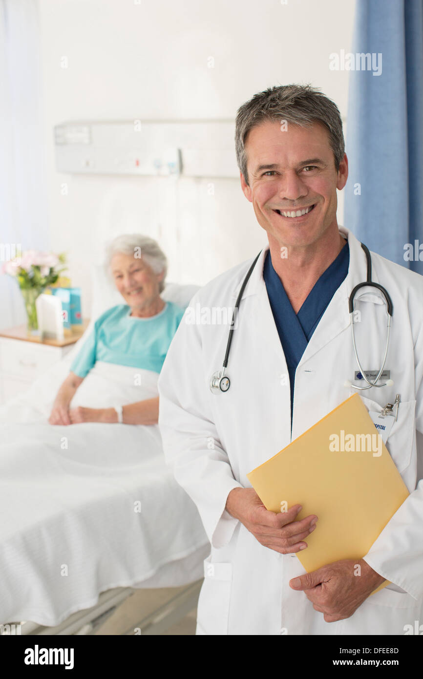 Porträt von lächelnden Arzt mit Patienten im Hintergrund Stockfoto