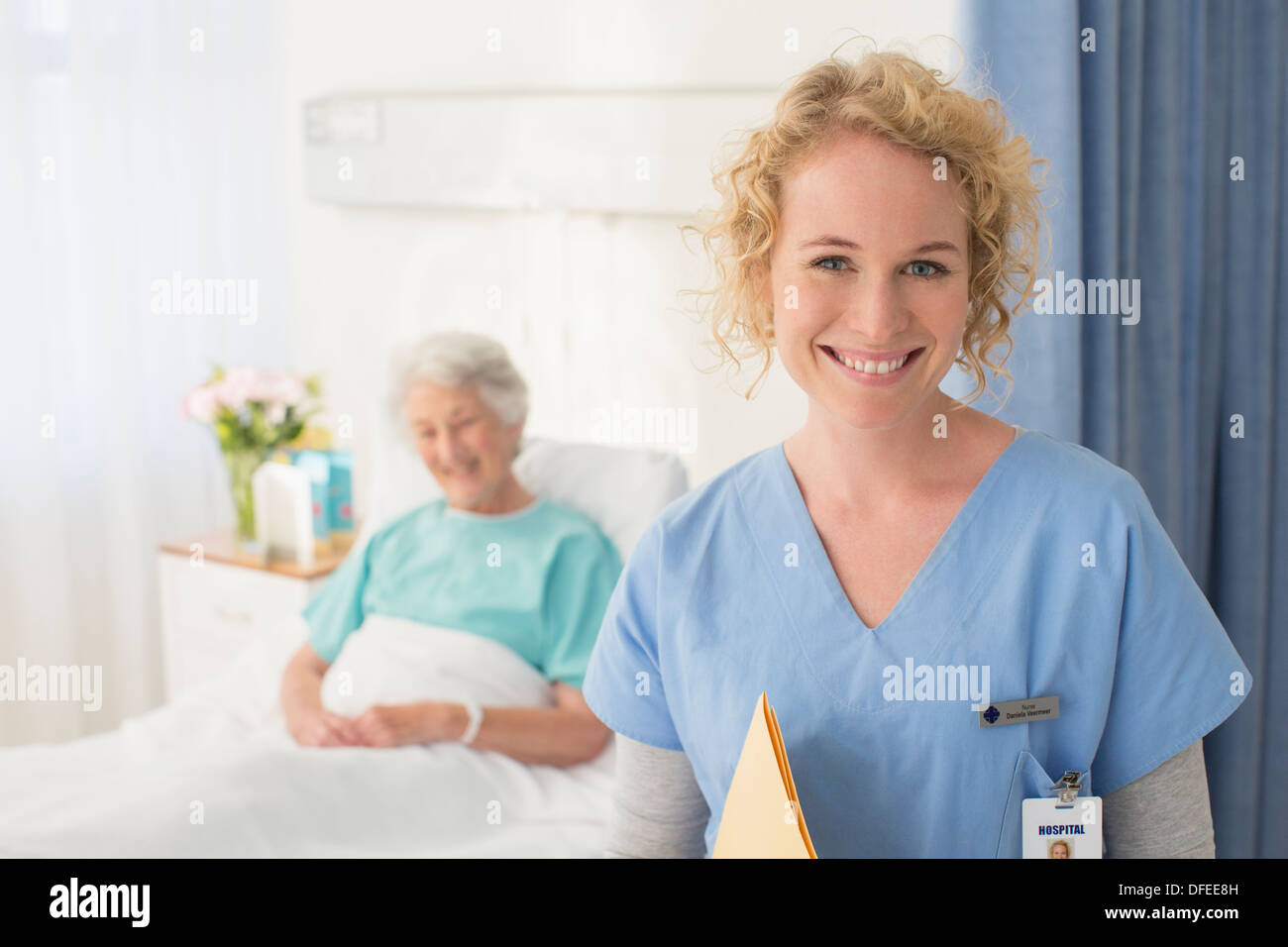 Porträt von lächelnden Krankenschwester mit älteren Patienten im Hintergrund Stockfoto