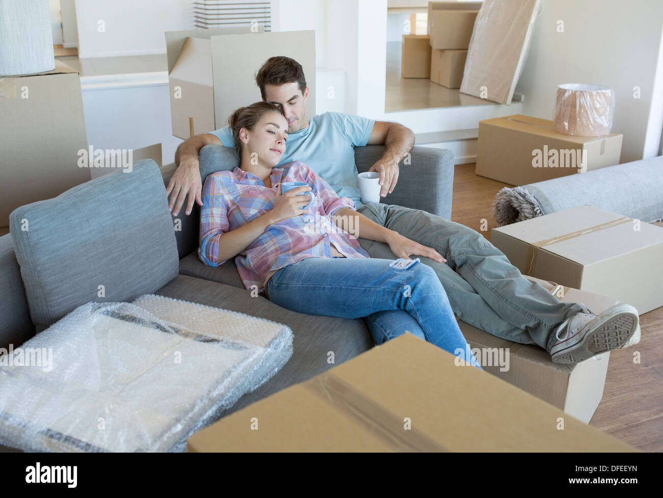 Paar erholsame auf Sofa im neuen Haus Stockfoto