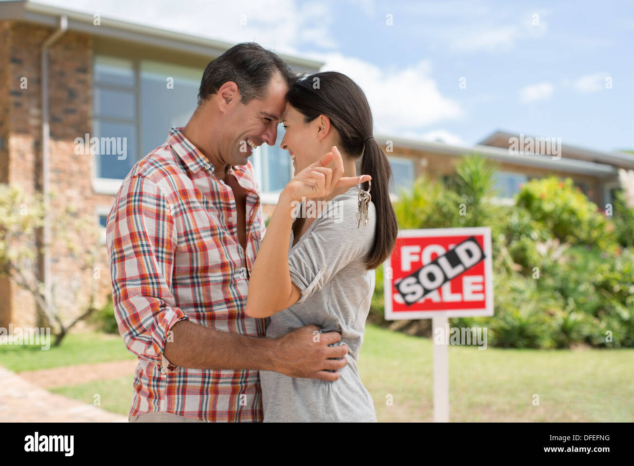 Paar umarmt außen neues Haus Stockfoto