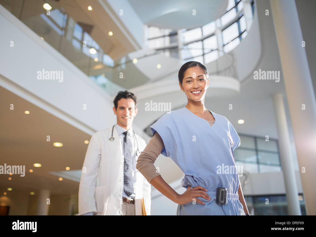 Porträt des Lächelns, Arzt und Krankenschwester im Krankenhaus atrium Stockfoto