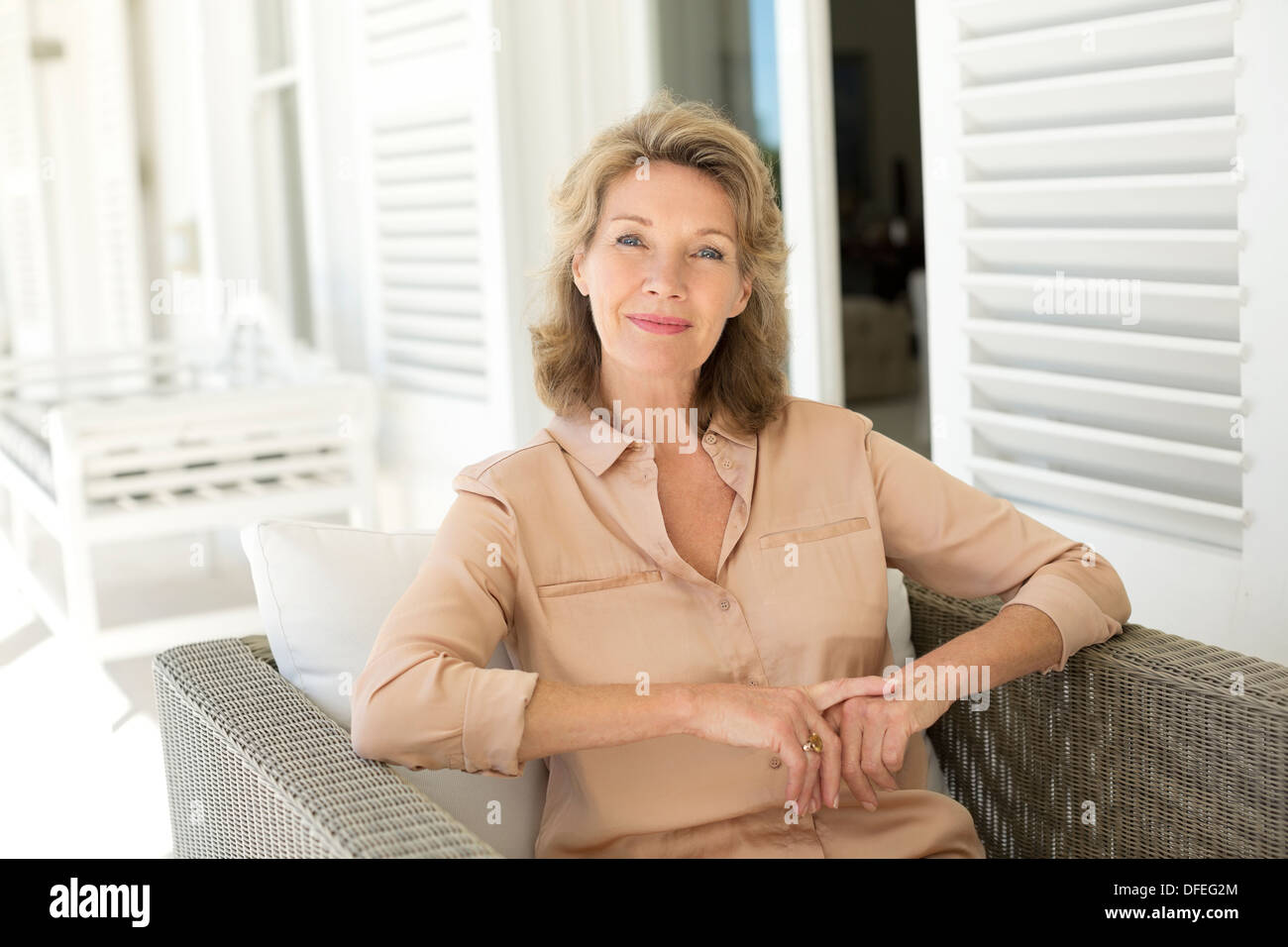 Porträt der lächelnde senior Frau sitzt auf Hof Stockfoto