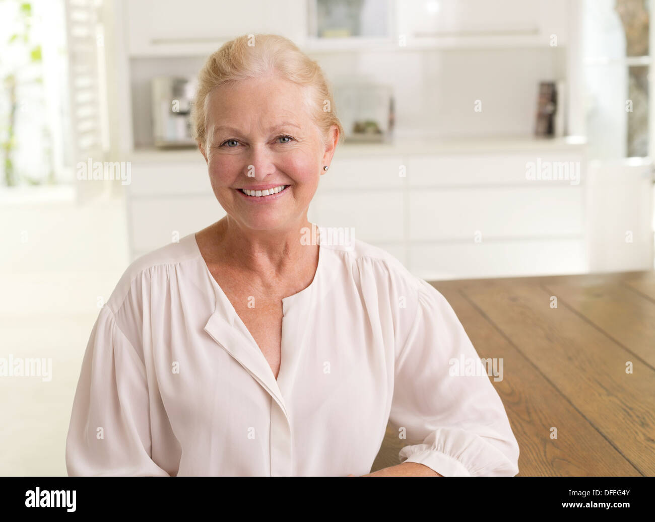 Ältere Frau lächelnd in Küche Stockfoto