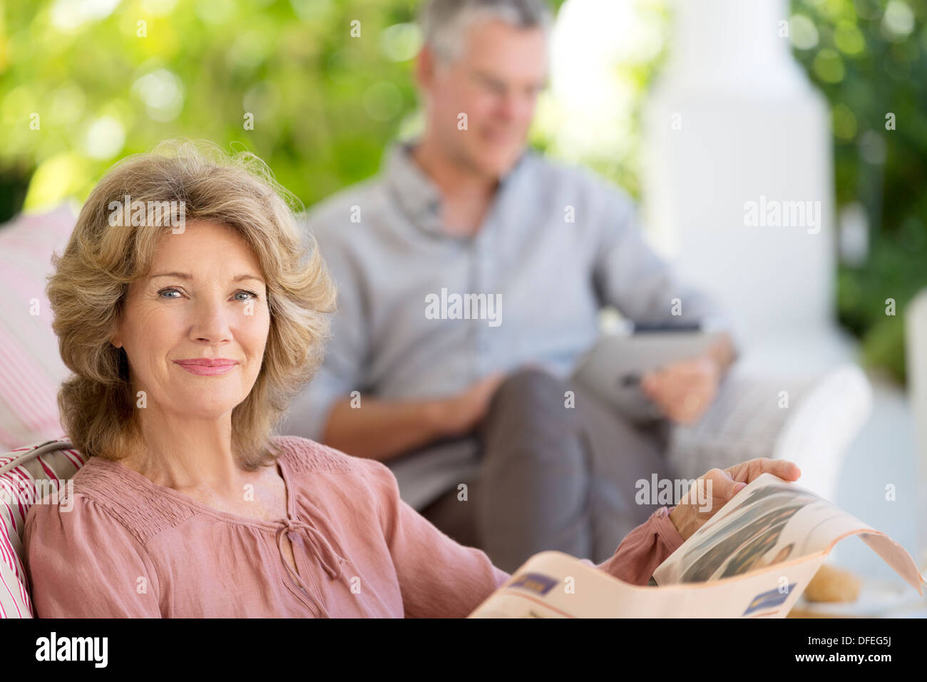 Ältere Frau liest Zeitung auf Terrasse Stockfoto