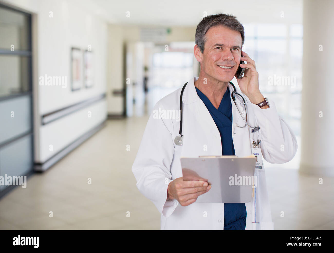 Arzt sprechen auf Handy im Krankenhausflur Stockfoto