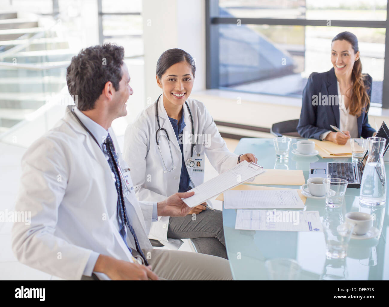 Ärzte und Geschäftsfrau in Sitzung sprechen Stockfoto
