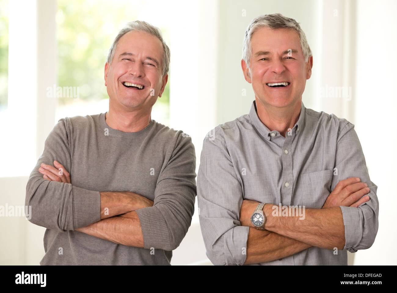 Porträt von Senioren Herren lachend mit verschränkten Armen Stockfoto