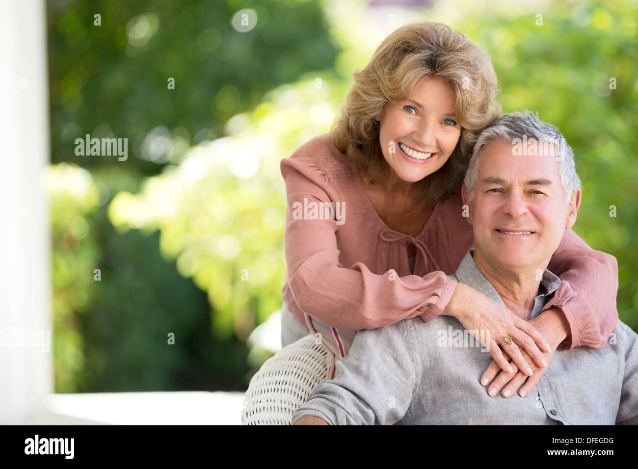 Älteres paar umarmt auf Terrasse Stockfoto