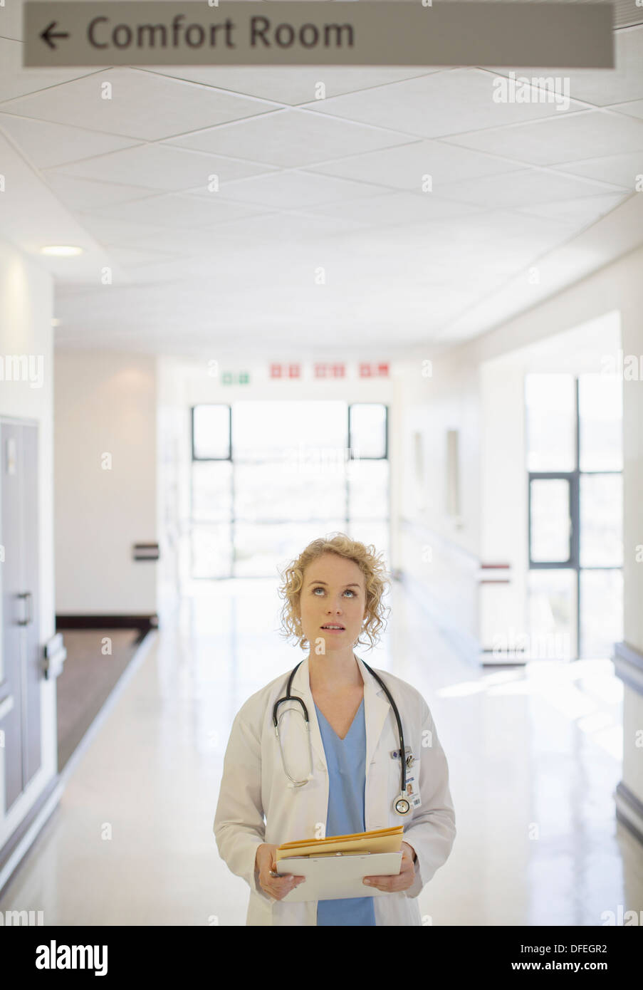 Arzt am Schild im Krankenhausflur nachschlagen Stockfoto