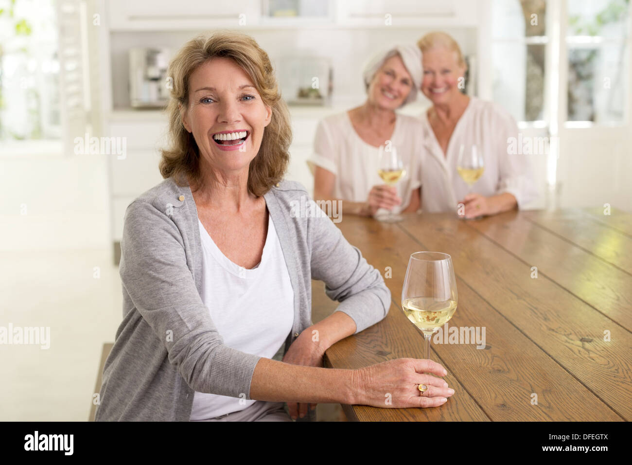 Porträt des Lächelns senior Frauen trinken Weißwein Stockfoto