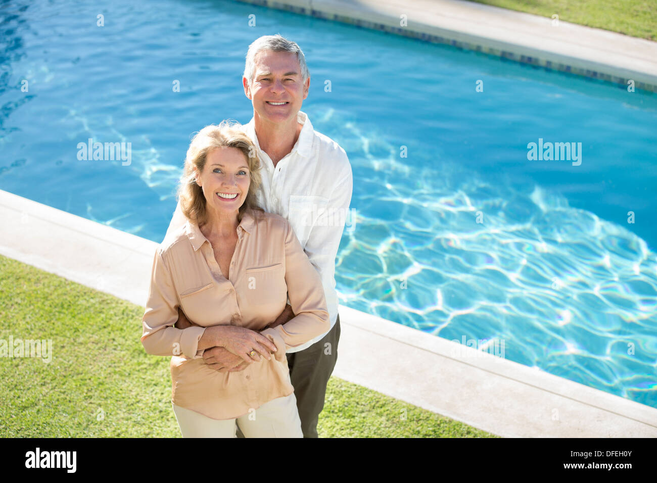 Porträt des Lächelns älteres Paar am Pool Stockfoto