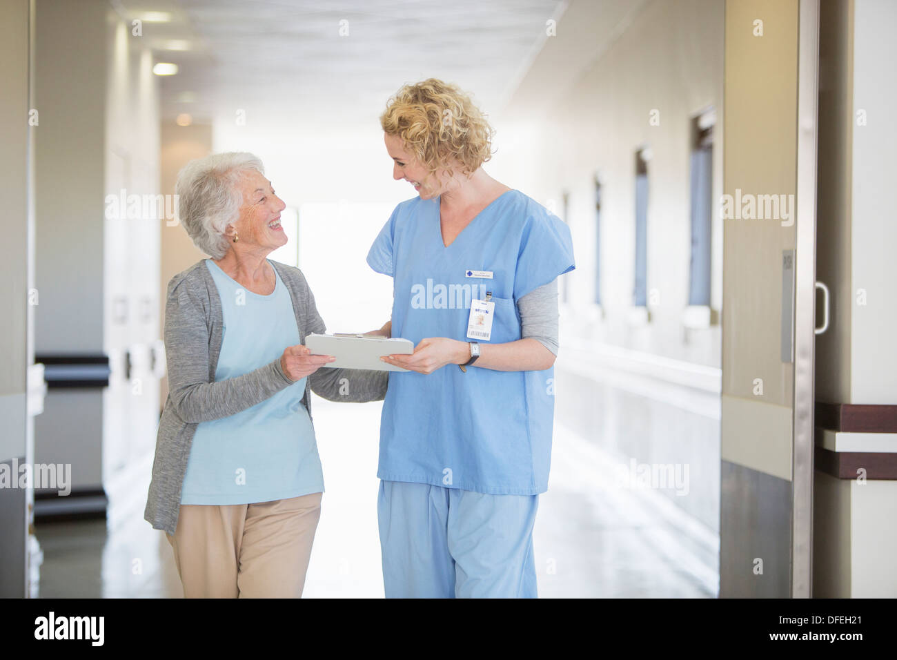 Krankenschwester und Senior Patienten sprechen im Krankenhausflur Stockfoto