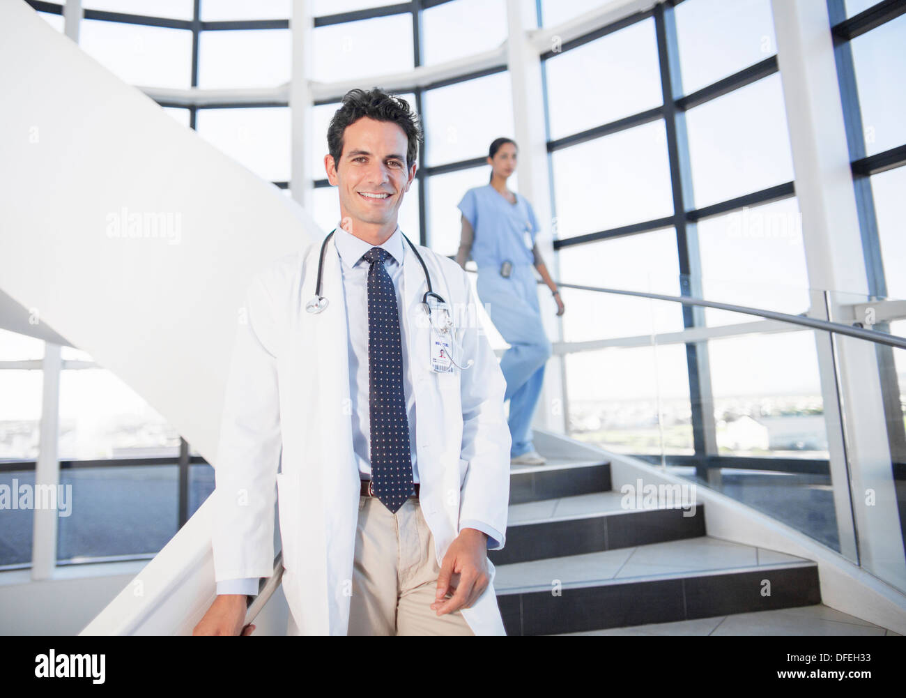 Porträt von lächelnden Arzt auf Treppe im Krankenhaus Stockfoto