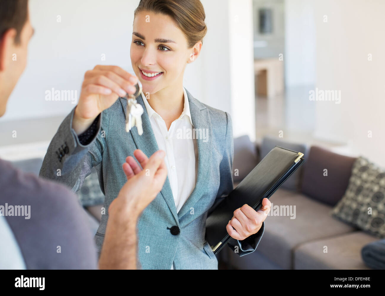 Grundstücksmakler, die dem Menschen Schlüssel zum neuen Haus Stockfoto