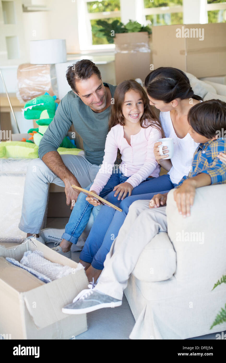Familie entspannend auf Sofa im neuen Haus Stockfoto