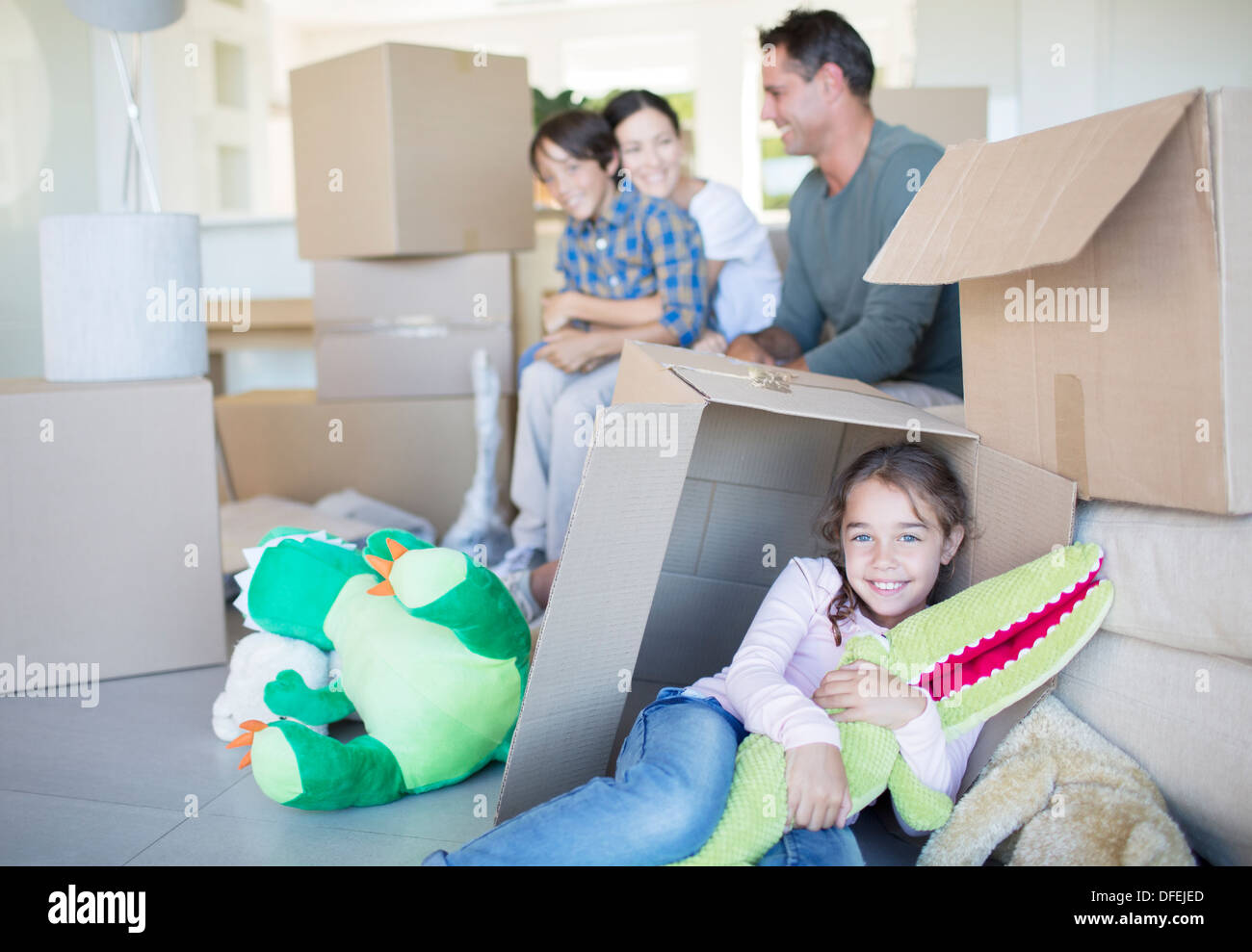 Familie unter den Kartons im Wohnzimmer Stockfoto
