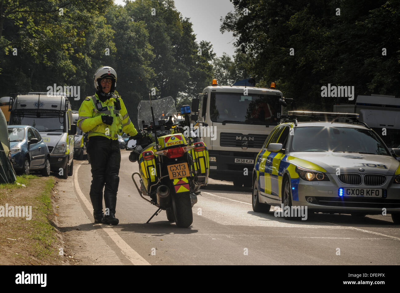 Polizei-Motorradfahrer aufgehoben, und das Polizeiauto zu stoppen Verkehr an Balcombe. Stockfoto