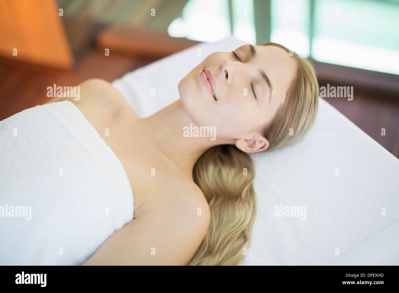 Lächelnde Frau am Massagetisch im Spa entspannen Stockfoto