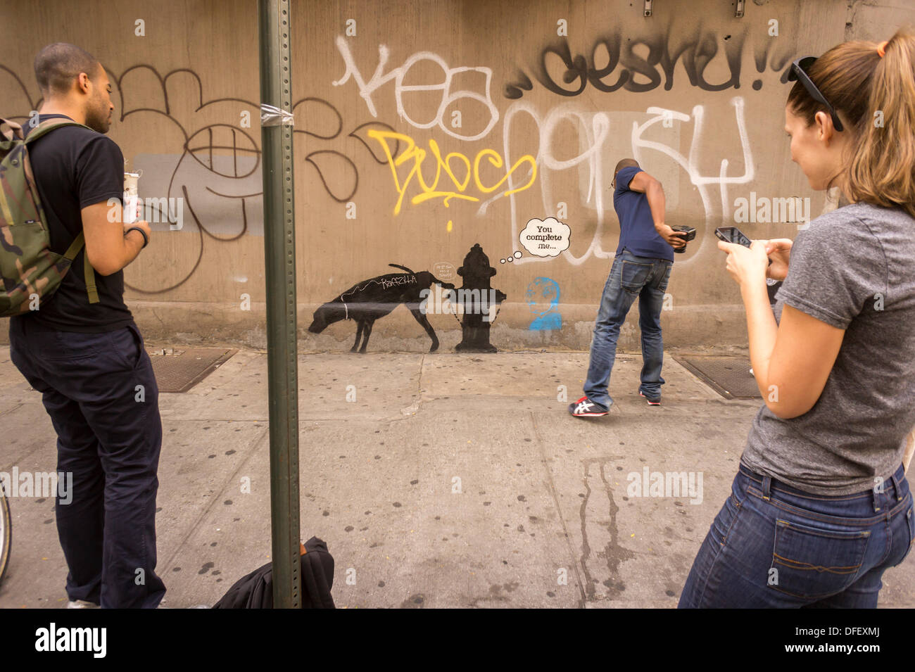 New York, USA. 3. Oktober 2013. Graffiti-Fans strömen in New Yorker Stadtteil Chelsea auf Donnerstag, 3. Oktober 2013, die dritte Tranche des Banky der Graffiti-Kunst zu sehen. Der schwer fassbaren Streetart-Künstler schaffen Werke rund um die Stadt, je Tag, im Laufe des Monats Oktober begleitet durch eine satirische aufgezeichnete Nachricht ein Museumsrundgang, die Sie bekommen können telefonisch unter der Nummer 1-800-656-4271 gefolgt von # und die Anzahl von Kunstwerken zu parodieren. Die Lage der Kunst findet entweder serendipitously oder per Crowdsourcing.  (© Richard B. Levine) Bildnachweis: Richard Levine/Alamy Live-Nachrichten Stockfoto