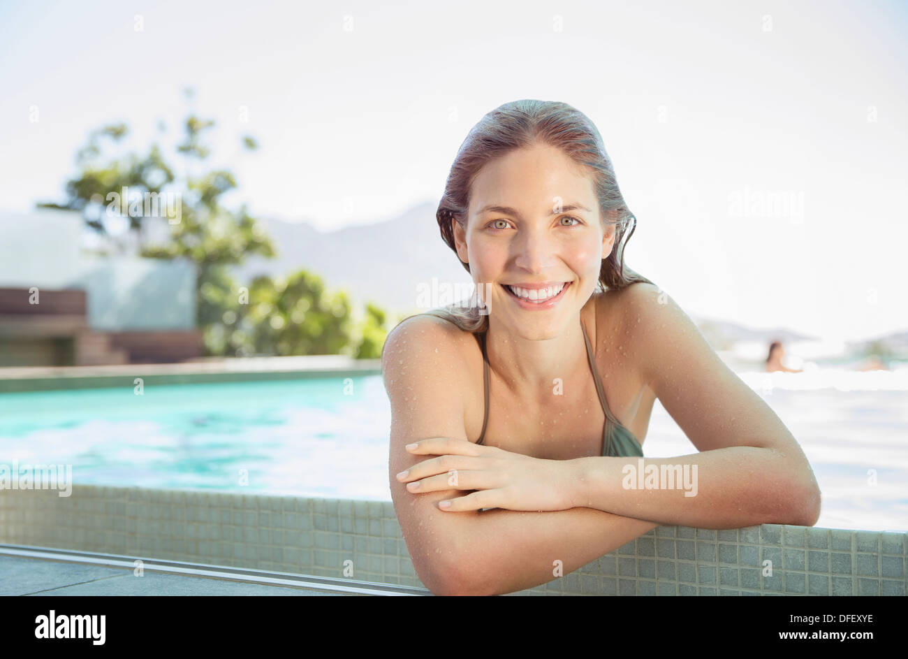 Porträt der lächelnde Frau am Rande des Schwimmbad Stockfoto