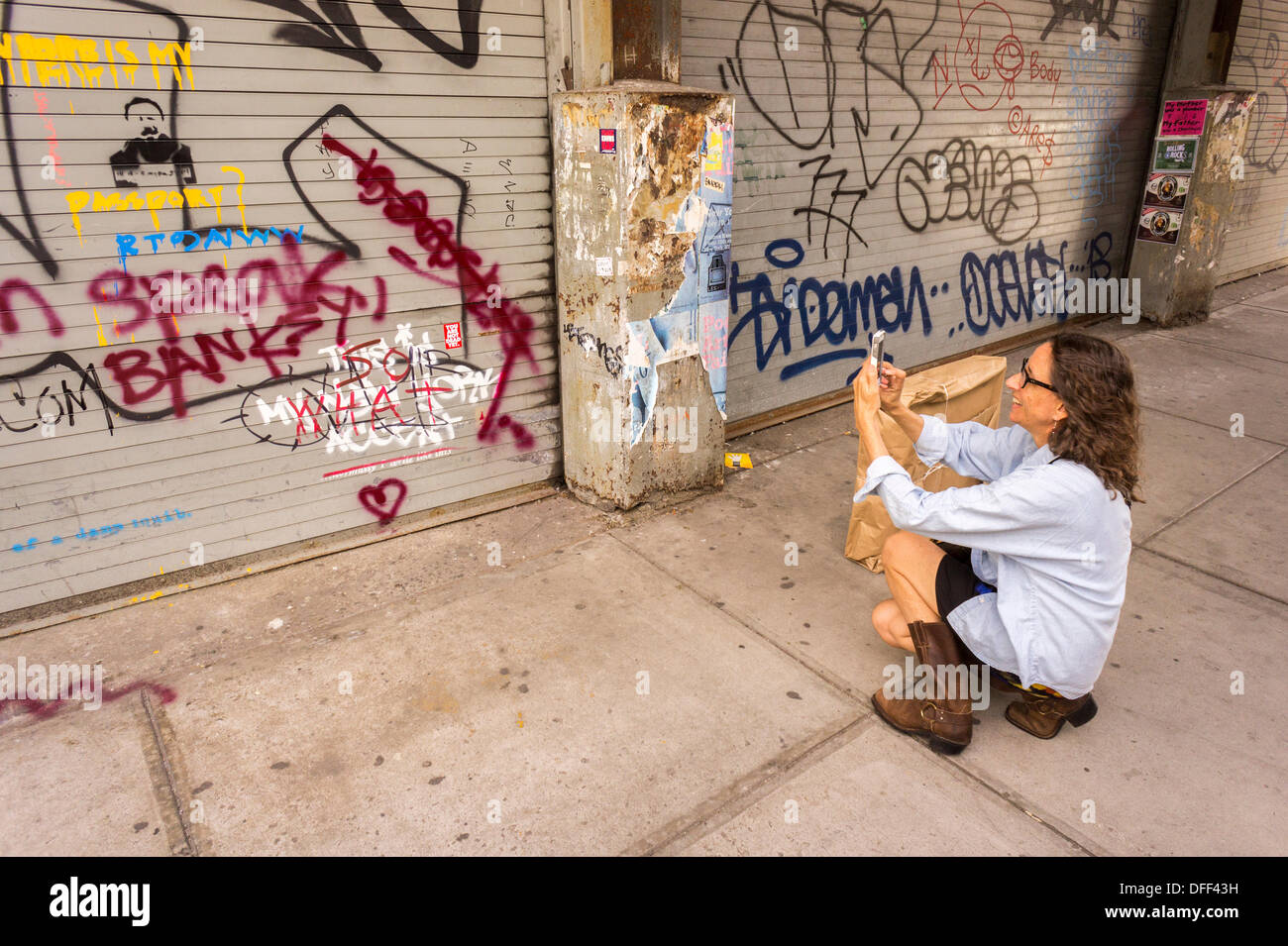 Zweite Tranche der Banksy-Graffiti-Kunst auf einer Rolle Tor im New Yorker Stadtteil Chelsea auf Donnerstag, 3. Oktober 2013, gemalt auf Mittwoch und bereits verwüstet. 'Das ist mein New York Akzent' Kunstwerk entstand durch die schwer fassbare Streetart-Künstler, die Werke in der Stadt, jeweils erstellen werden Tag, im Laufe des Monats Oktober. Die Schablonen sind begleitet von eine satirische aufgezeichnete Nachricht ein Museumsrundgang, die Sie hören können telefonisch unter der Nummer 1-800-656-4271 gefolgt von # und die Anzahl von Kunstwerken zu parodieren.  (© Richard B. Levine) Stockfoto