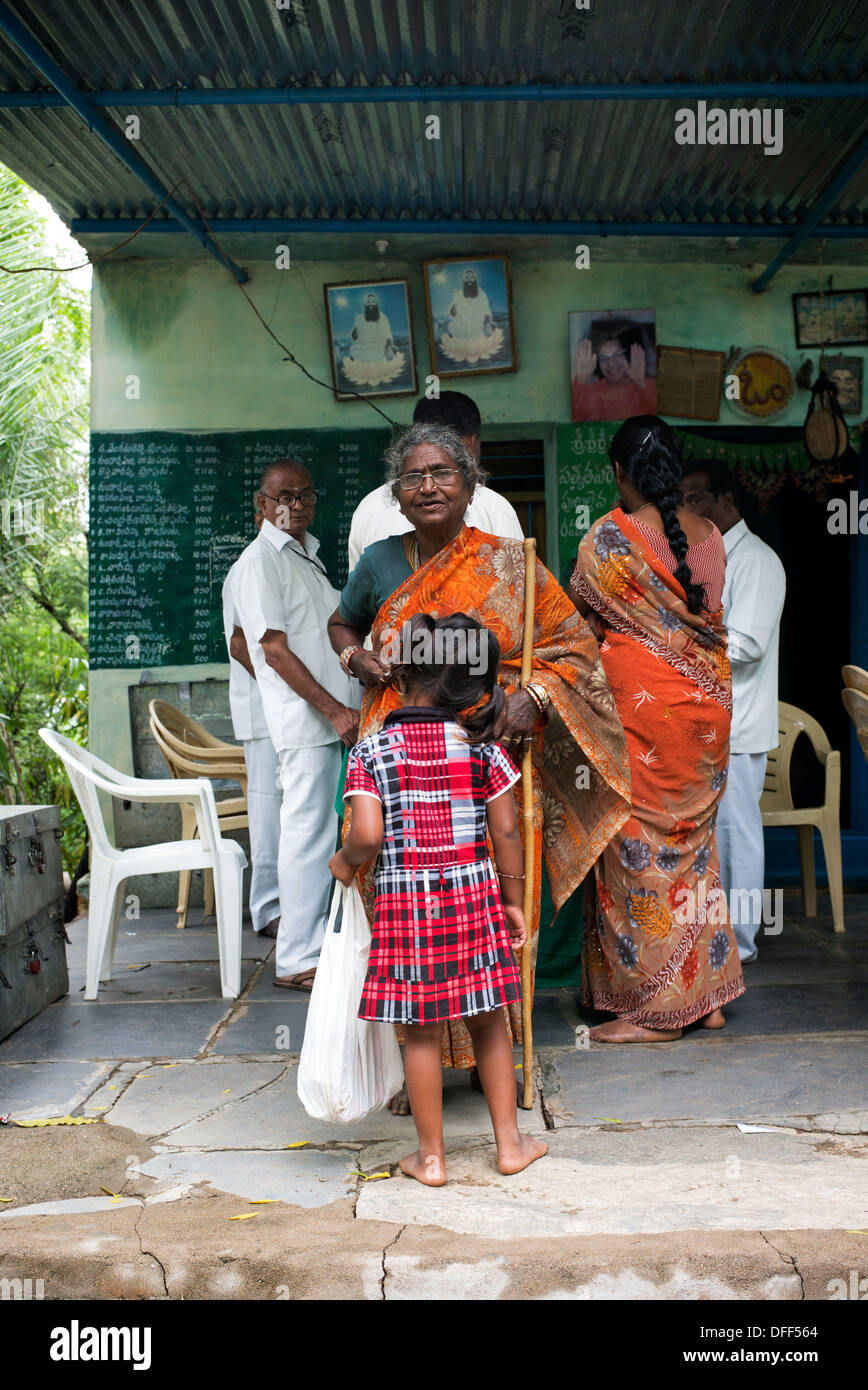 Indisches Kind helfen Oma an der Sri Sathya Sai Baba mobile aufsuchende Krankenhausapotheke. Indien Stockfoto