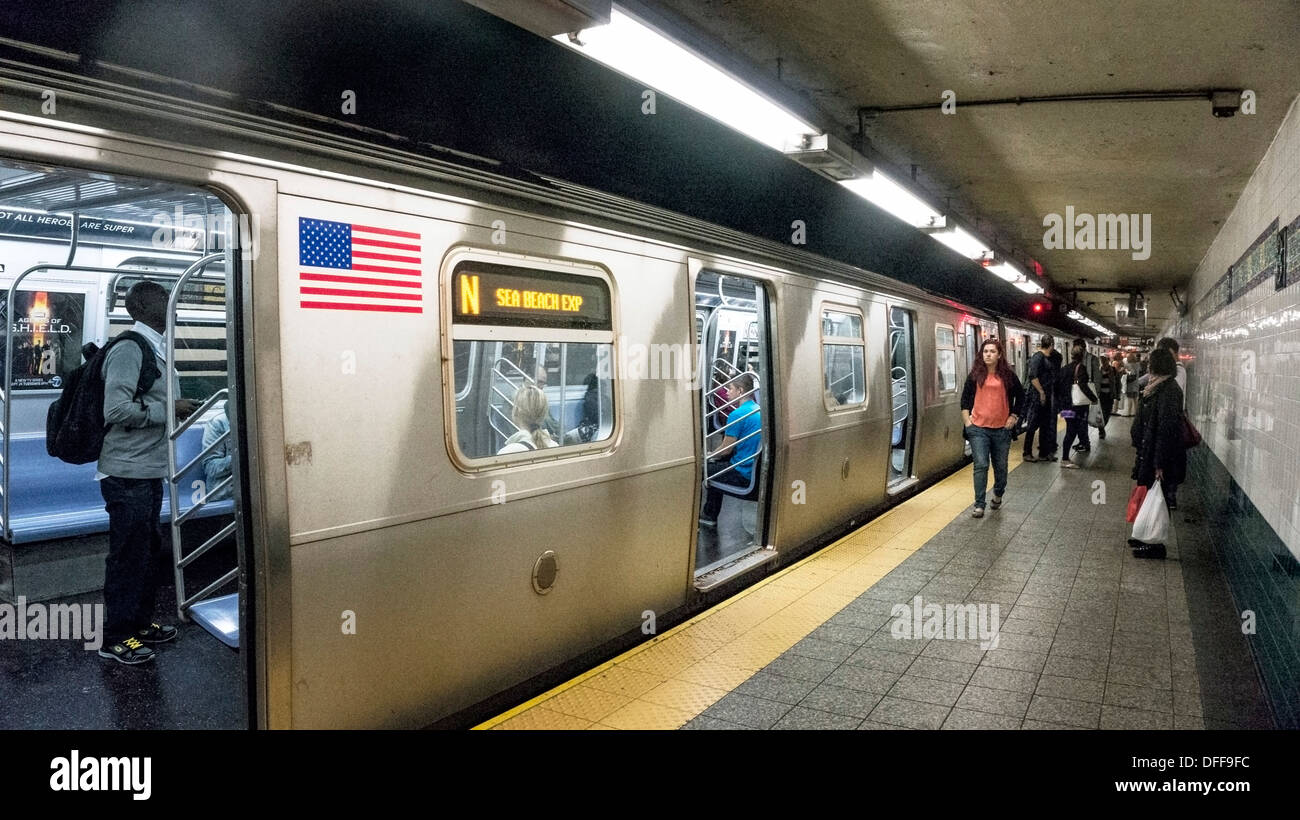 diverse Passagiere auf Plattform & innen Zug als N-Line-Zug macht Halt Manhattan Chinatown Canal Street u-Bahnstation Stockfoto