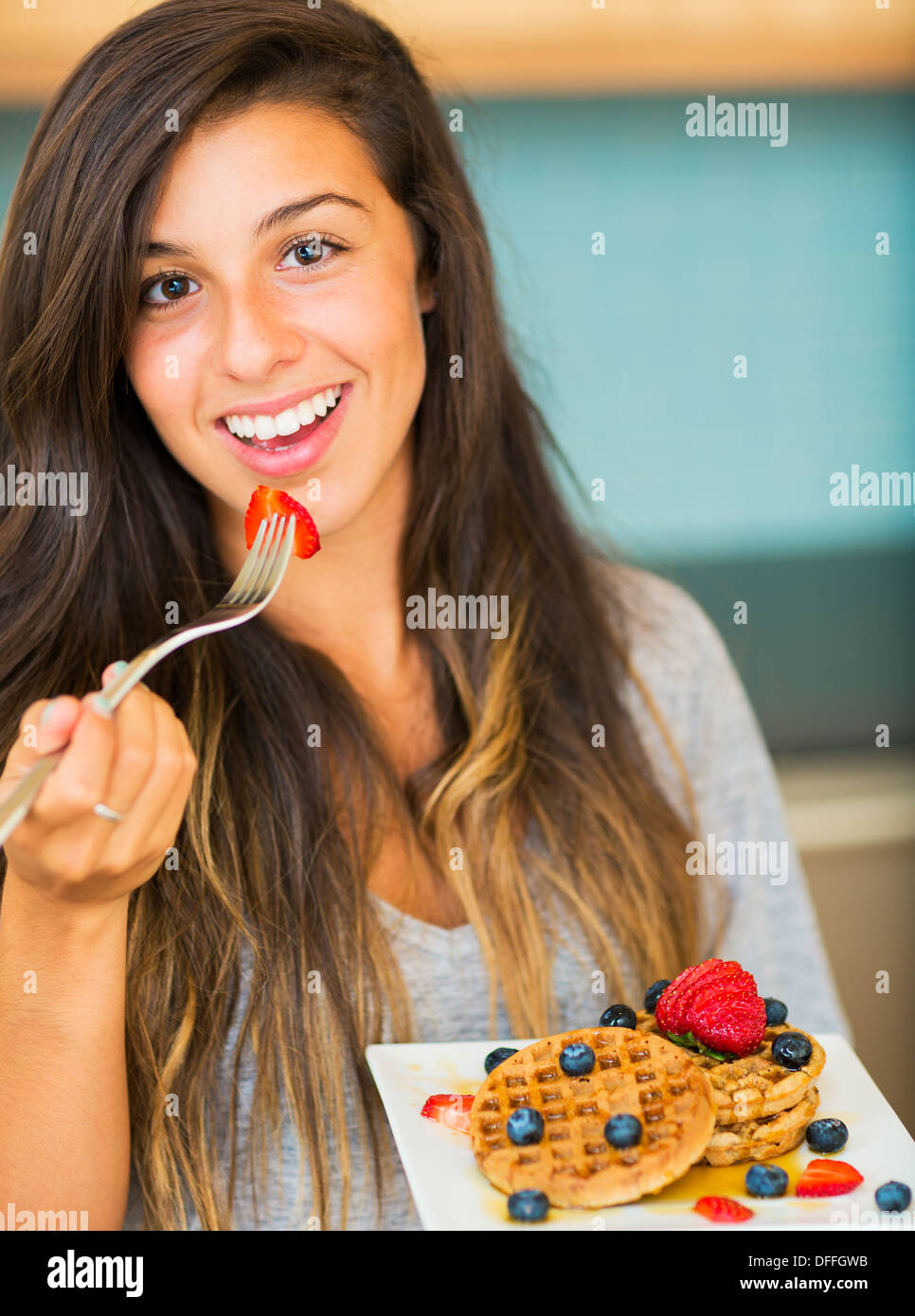 Frau essen Waffeln mit frischem Obst zum Frühstück Stockfoto