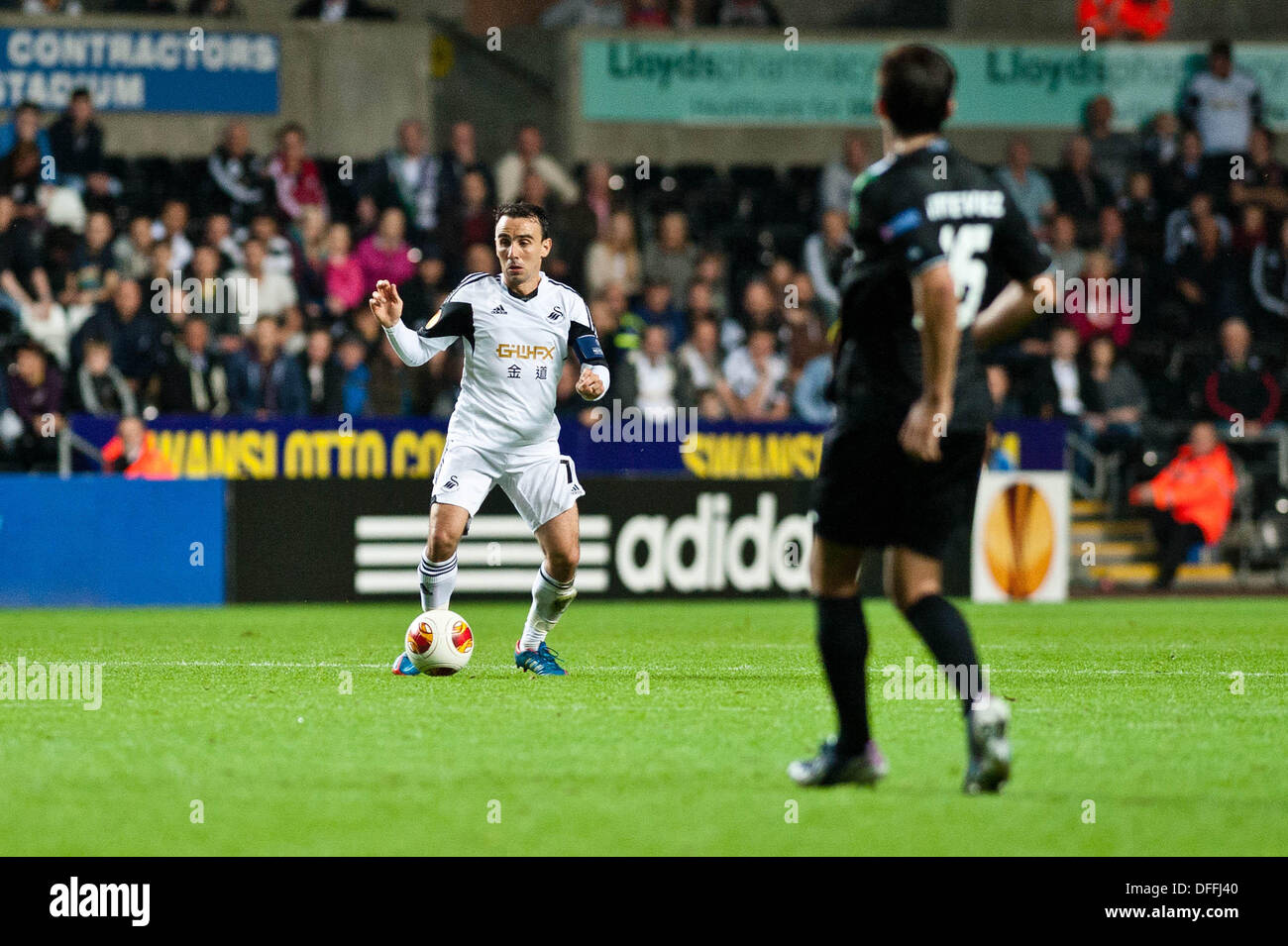 Swansea, Großbritannien. 3. Oktober 2013.   Im Bild: Leon Britton (mit Ball) gegen Matias Vitkieviez St Gallen (R) Re: UEFA Europa League, Swansea City FC Vs FC St. Gallen, an der Liberty Staduim Swansea Kredit: D Legakis/Alamy Live News Stockfoto