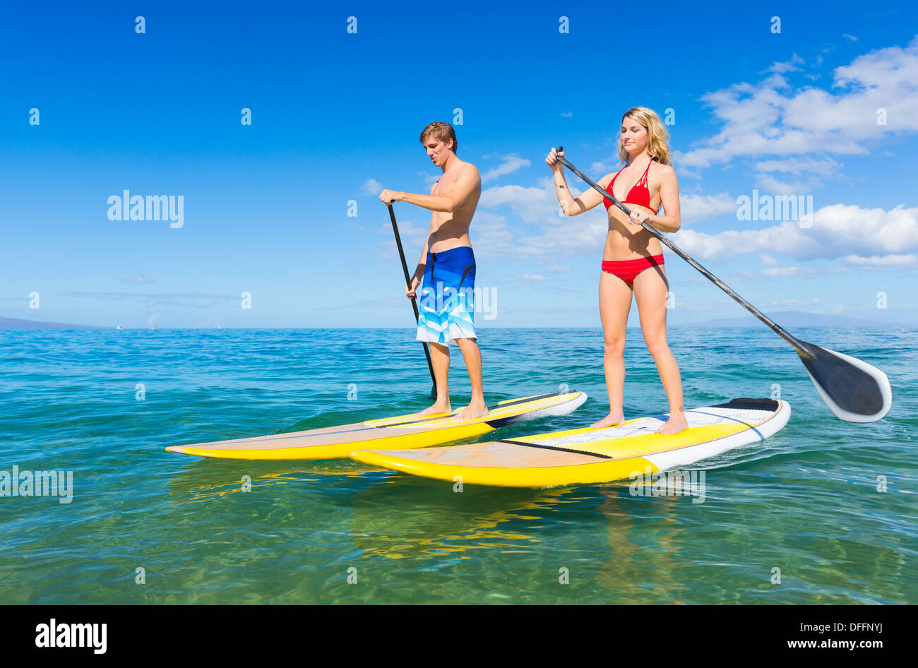 Paar Stand Up Paddle Surfen In Hawaii, schönen tropischen Ozean aktiv Strand Lebensstil Stockfoto