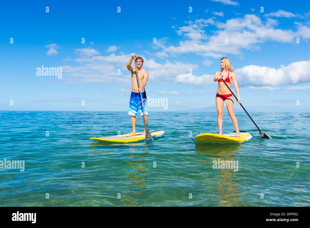 Paar Stand Up Paddle Surfen In Hawaii, schönen tropischen Ozean aktiv Strand Lebensstil Stockfoto