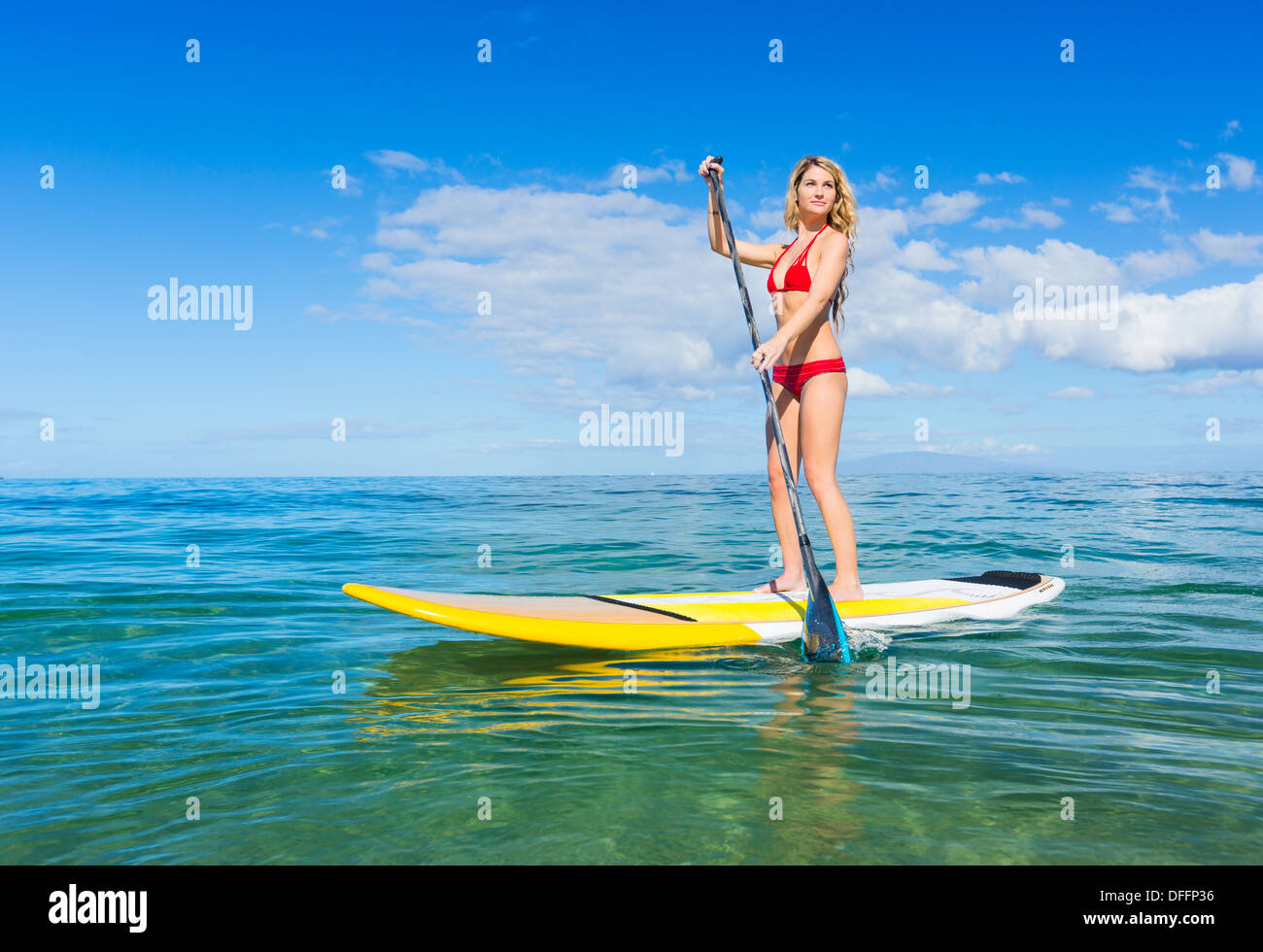 Attraktive junge Frau Stand Up Paddle Surfen In Hawaii, schönen tropischen Ozean aktiv Strand Lebensstil Stockfoto