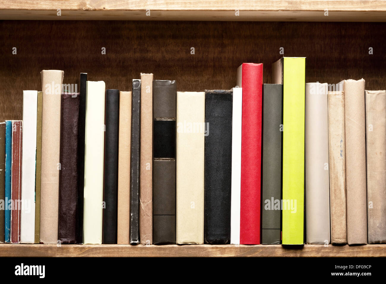 Alte Bücher auf einem Holzregal. Keine Etiketten, leere Wirbelsäule. Stockfoto