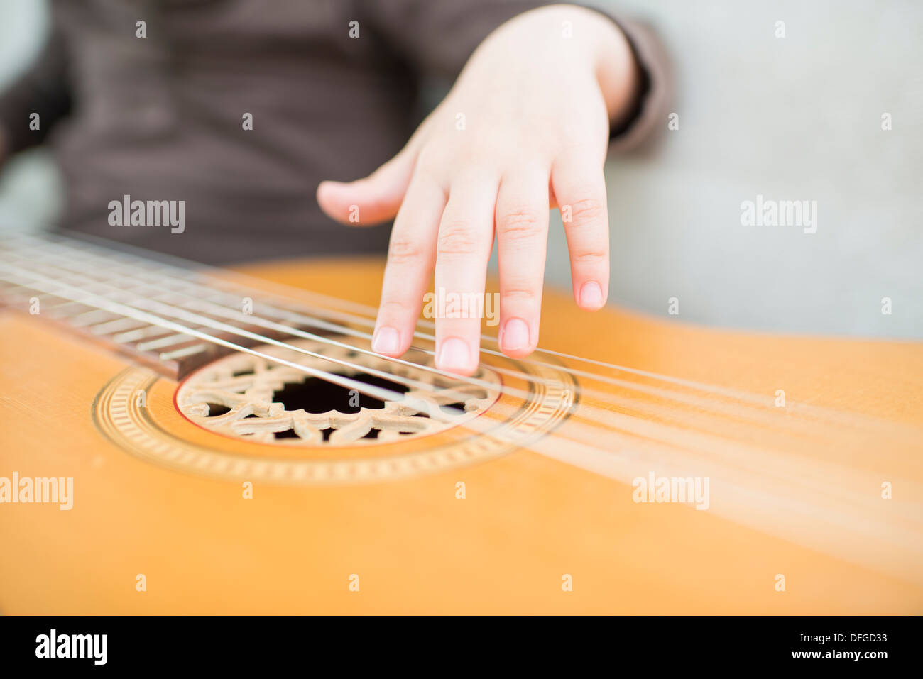 Junges Mädchen, 4 Jahre alt, auf einer akustischen Gitarre zu spielen. Stockfoto