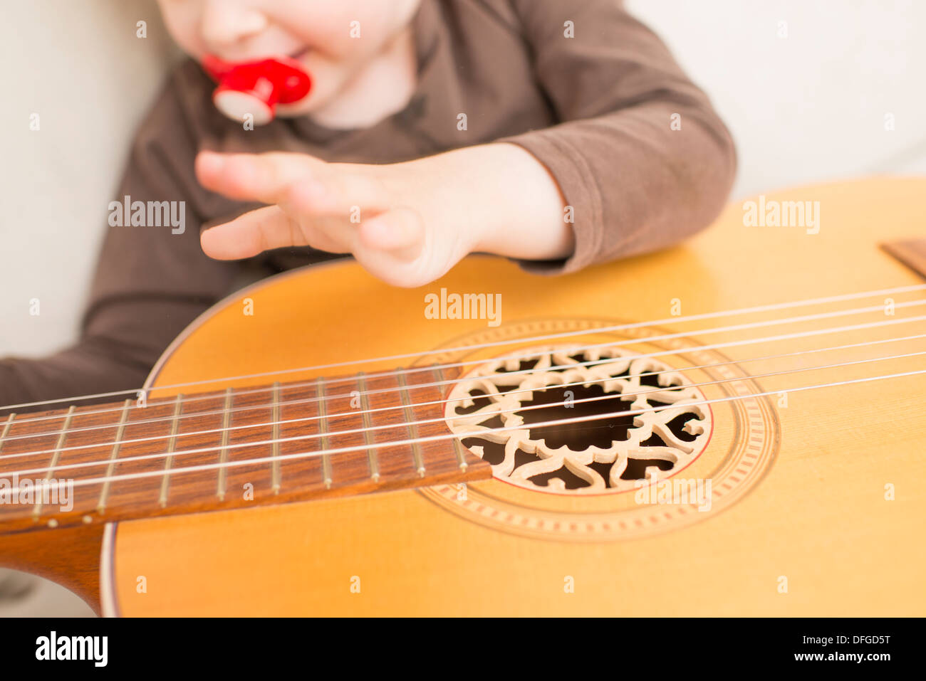 Junges Mädchen, 4 Jahre alt, mit einer akustischen Gitarre zu spielen. Stockfoto