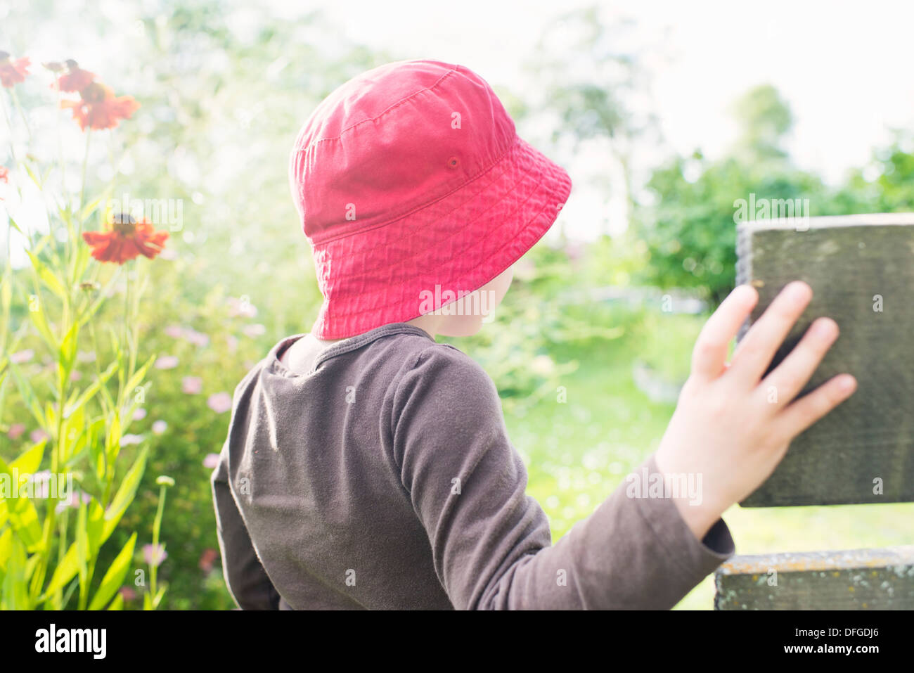 Lifestyle-Moment mit junge Mädchen beobachten einen Garten voller Blumen und Grünpflanzen Stockfoto